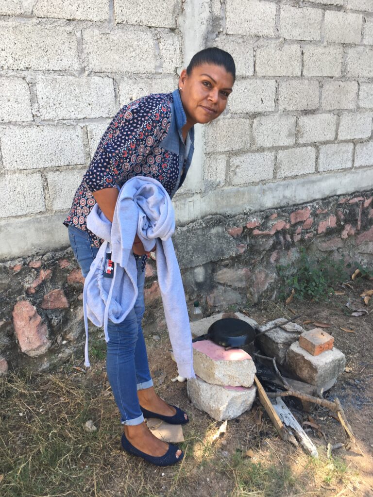 His mom's outdoor "kitchen"  made of bricks and a pan